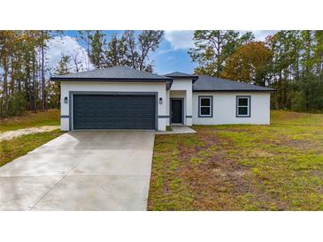 One-story house with gray garage door and white exterior at 6264 Sw 144Th Pl, Ocala, FL 34473