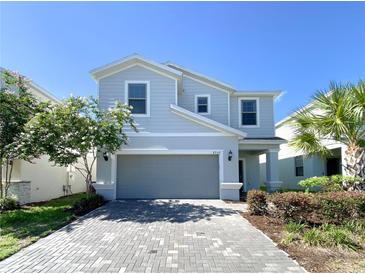 Two-story house with gray siding, gray garage door, and a paved driveway at 8956 Zurich Ln, Kissimmee, FL 34747
