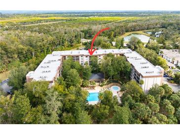 Aerial view of condo building, pool, and surrounding landscape at 640 N Nova Rd # 510, Ormond Beach, FL 32174