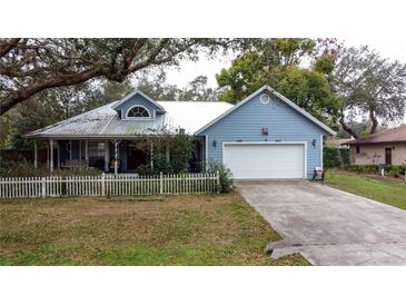 Charming blue house with white picket fence and large yard at 1215 Timberidge Dr, Lakeland, FL 33809