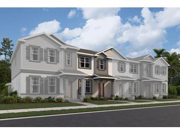 Three-story townhome with gray siding, multiple windows, and landscaping at 600 Pothos St, Apopka, FL 32703