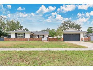 Attractive ranch-style home with brick facade and updated garage doors at 4132 Yorketowne Rd, Orlando, FL 32812