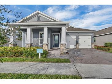 Beautiful two-story home with gray exterior, white columns, and a two-car garage at 15155 Mayberry Dr, Winter Garden, FL 34787