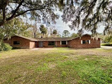Ranch style brick home with large yard and mature trees at 227 N Kepler Rd, Deland, FL 32724