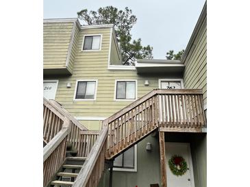 Exterior view of a light green two-story building with stairs and a wreath on the door at 262 Scottsdale Sq # 262, Winter Park, FL 32792
