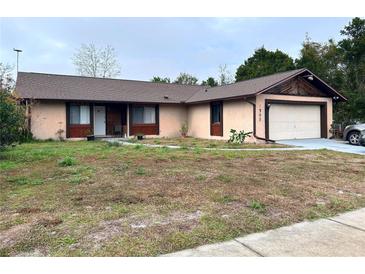 Single-story house with a brown roof, attached garage, and a yard at 2708 Sedgefield Avenue, Deltona, FL 32725