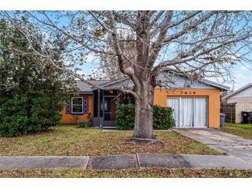 Ranch style home with orange exterior, screened porch and mature landscaping at 7879 Toledo St, Orlando, FL 32822