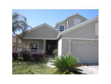 Two-story house with neutral siding and landscaping at 152 Dakota Ave, Groveland, FL 34736