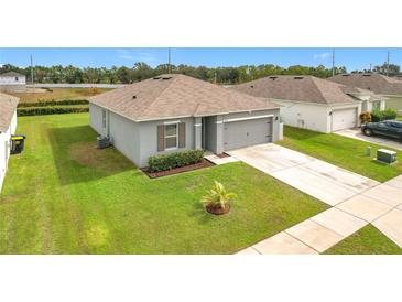 One-story home with gray exterior, driveway, and landscaped lawn at 440 Burnham Cir, Auburndale, FL 33823