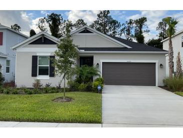 One-story home with gray exterior, dark brown garage door, and landscaped lawn at 1020 Lakeside Estates Dr, Apopka, FL 32703