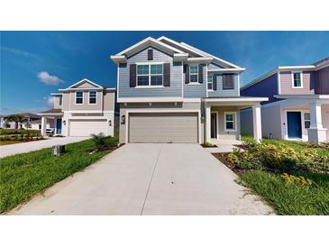 Two-story house with gray siding, neutral garage door, and landscaping at 1618 Reservoir Pl, Davenport, FL 33837