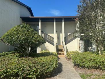 Inviting condo building entrance with lush landscaping and stairs at 1310 Stearman Ct # 4, Orlando, FL 32825