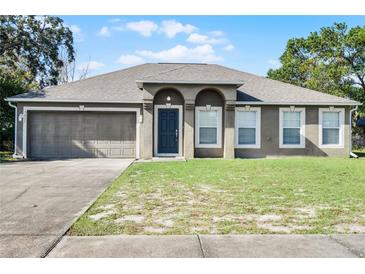Single-story house with a two-car garage and well-maintained lawn at 3621 Ronda Dr, Deltona, FL 32738