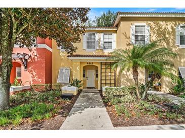 Inviting two-story townhome with attractive landscaping and a welcoming front entrance at 8443 Crystal Cove Loop, Kissimmee, FL 34747