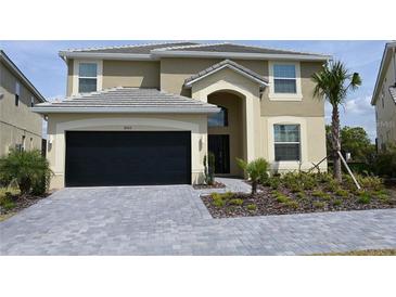 Two-story house with a two-car garage and landscaped yard at 2553 Shanti Dr, Kissimmee, FL 34746