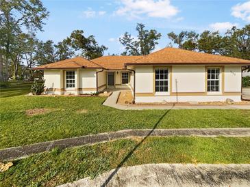 Single-story home with brown roof and well-maintained lawn at 5933 Bible Camp Rd, Groveland, FL 34736