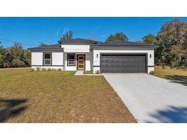 Modern, single-story home with white walls, black trim, and a two-car garage at 6215 148Th Southwest, Ocala, FL 34473