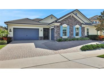 Beautiful stone and shingle exterior, two-car garage, and paved driveway at 3875 Grassland Loop, Lake Mary, FL 32746