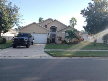 Single-story home with a two-car garage and well-maintained lawn at 7947 Golden Pond Cir, Kissimmee, FL 34747