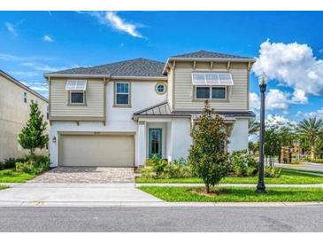 Two-story house with light-colored siding, a three-car garage, and landscaping at 8929 Amelia Downs Trl, Kissimmee, FL 34747