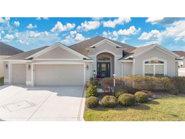 Beautiful one-story home with a two-car garage and manicured landscaping at 5810 Penney Ln, The Villages, FL 32163