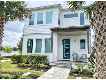 Two-story home with white siding, teal door, and landscaped front yard at 8348 Lindahl Aly, Orlando, FL 32827