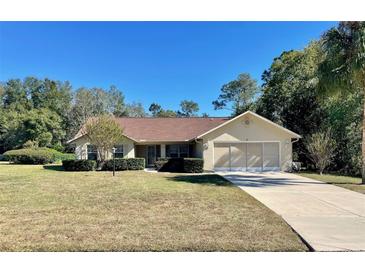 Single-story house with a two-car garage and landscaped yard at 10787 Sw 53Rd Cir, Ocala, FL 34476