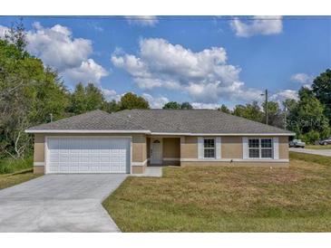 One-story home with attached garage and driveway at 12472 Sw 85Th Pl, Dunnellon, FL 34432