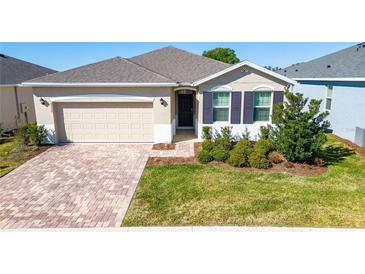 One-story house with beige siding, brown shutters, and paved driveway at 4336 Nw 55Th Ct, Ocala, FL 34482