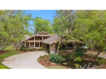 Stunning home exterior with a stone facade and pond feature at 2162 Se Mill Creek Cir, Ocala, FL 34471