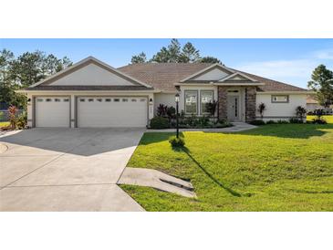 Beautiful house with three car garage and manicured lawn at 5005 Sw 106Th St, Ocala, FL 34476