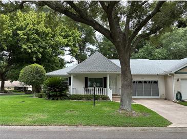 White single-story home with gray roof and lush landscaping at 8420 Sw 92Nd St # A, Ocala, FL 34481
