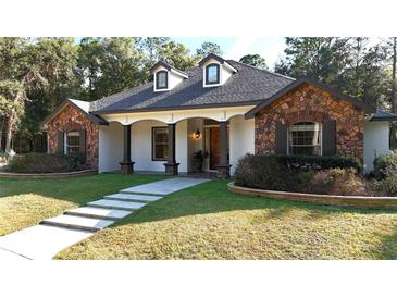 Beautiful stone and stucco home with a lush green lawn at 5894 Ne 43Rd Lane Rd, Silver Springs, FL 34488