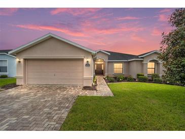One-story house with a beige exterior and brick driveway at 16292 Sw 13Th Ter, Ocala, FL 34473
