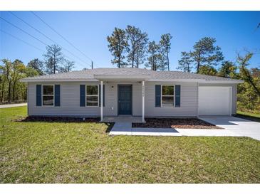 Charming single-story home with a gray exterior and attached garage at 24449 Nw Falcon Ave, Dunnellon, FL 34431