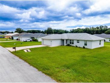 Single-story home with a spacious lawn and driveway at 1436 Ne 161St Pl, Citra, FL 32113
