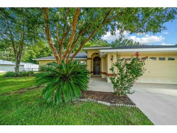 House entrance with lush landscaping and a large tree at 5311 Se 15Th Ct, Ocala, FL 34480