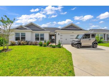 Single-story home with a two-car garage and landscaped yard at 1789 Usrey Ct, The Villages, FL 34762