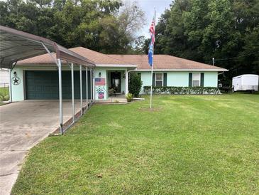 Light green house with carport and well-maintained lawn at 6690 Cherry Rd, Ocala, FL 34472