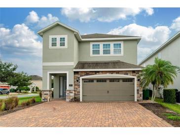 Two-story house with stone accents and a two-car garage at 7694 Graben St, Kissimmee, FL 34747