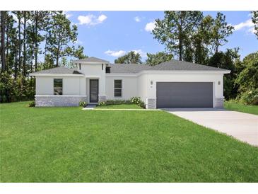 Modern one-story house with gray garage and stone accents at 7058 Sw 129Th Pl, Ocala, FL 34473