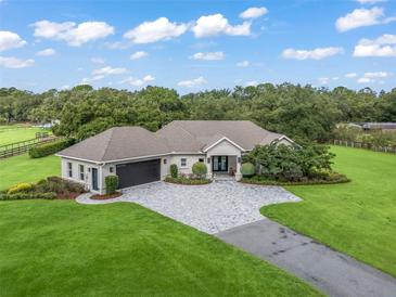 Aerial view of a single-Gathering home with a large lawn at 1620 Nw 73Rd Ter, Ocala, FL 34482