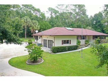 Home exterior showcasing large yard and driveway at 21389 Sw 102Nd Street Rd, Dunnellon, FL 34431