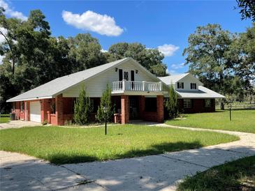 Two-story home with brick exterior and a balcony at 9526 Sw 72Nd Ct, Ocala, FL 34476