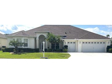 Beautiful one-story home with a three-car garage and lush landscaping at 5858 Nw 27Th Pl, Ocala, FL 34482
