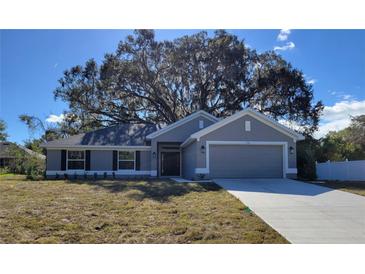 Newly constructed home with gray exterior, two-car garage, and manicured lawn at 7576 Sw 102Nd Loop, Ocala, FL 34476