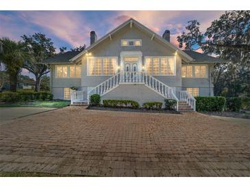 Two-story house with gray siding, white trim, and a brick driveway at 1218 Se 11Th St, Ocala, FL 34471