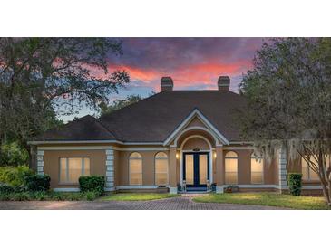 Tan two-story house with a double door entry and manicured lawn at 2210 Se Laurel Run Dr, Ocala, FL 34471