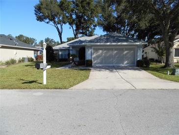 Single-story home with attached garage and well-manicured lawn at 10970 Sw 69Th Cir, Ocala, FL 34476