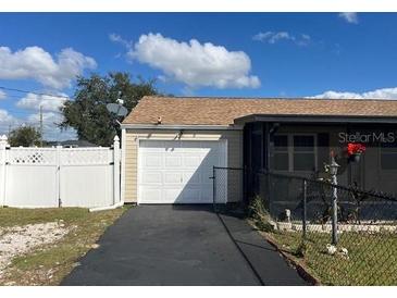 Single car garage with driveway and white vinyl fence at 1 Willow Ct, Ocala, FL 34472
